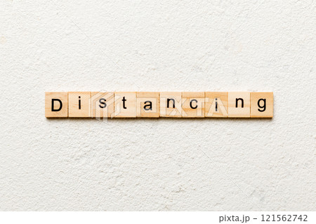 distancing word written on wood block. distancing text on cement table for your desing, concept distancing word written on wood block. distancing text on cement table for your desing, concept 121562742