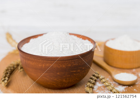 Flat lay of Wheat flour in wooden bowl with wheat spikelets on colored background. world wheat crisis 121562754