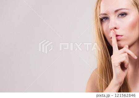 Woman asking for silence with finger on lips 121562846
