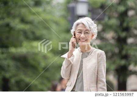スマートフォンで通話する笑顔のシニア女性 スマートフォンで通話する笑顔のシニア女性 121563997