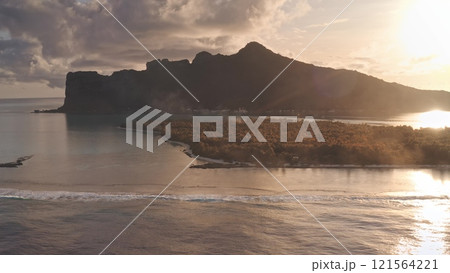 Golden sunset over Maupiti tropical island, French Polynesia. Barrier reef waves breaking shore, mount Teurafaatui silhouette in the background. Remote wild nature summer vacation travel. Aerial shot Golden sunset over Maupiti tropical island, French Polynesia. Barrier reef waves breaking shore, mount Teurafaatui silhouette in the background. Remote wild nature summer vacation travel. Aerial shot 121564221