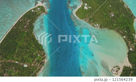 Breathtaking aerial top down view of water channel bay entrance to the lagoon Maupiti island in French Polynesia, vibrant coral reefs, and lush green vegetation, creating a stunning tropical paradise 121564239