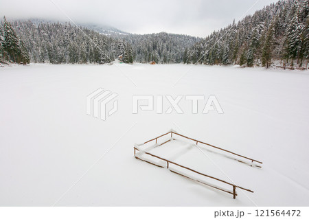 carpathian mountain winter landscape. spruce woods. snow covered frozen lake. scenery in synevyr national park, ukraine. cloudy weather. travel destination background. wintry morning 121564472