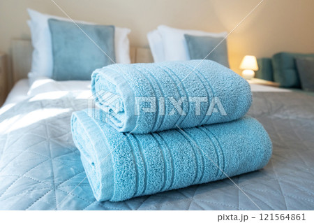 turquoise towels on bed in guest room in hotel 121564861
