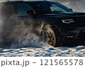 extreme driving, the car is moving rapidly over the smooth snow and creates a spray of snow. 121565578