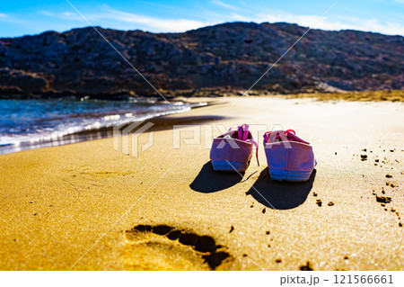 Female sneakers on sand beach Female sneakers on sand beach 121566661