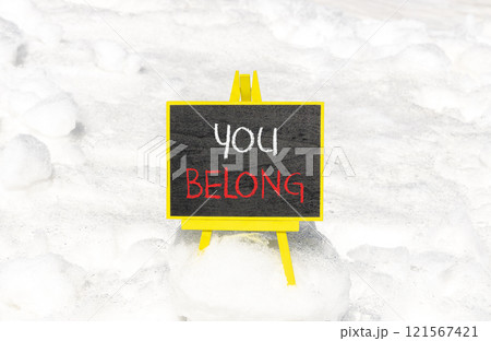 Belonging and you belong symbol. Concept words You belong on beautiful yellow chalk blackboard. Beautiful white snow background. Business belonging and you belong concept. Copy space. Belonging and you belong symbol. Concept words You belong on beautiful yellow chalk blackboard. Beautiful white snow background. Business belonging and you belong concept. Copy space. 121567421