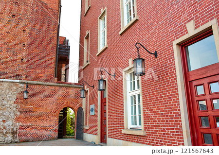 The old red brick Zamek Krolewski na Wawelu Castle is surrounded by green flowering plants in the center of Krakow. The old red brick Zamek Krolewski na Wawelu Castle is surrounded by green flowering plants in the center of Krakow. 121567643