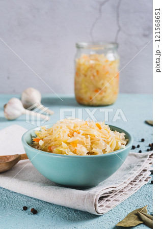 Pickled sauerkraut with carrots in a bowl on the table vertical view 121568651