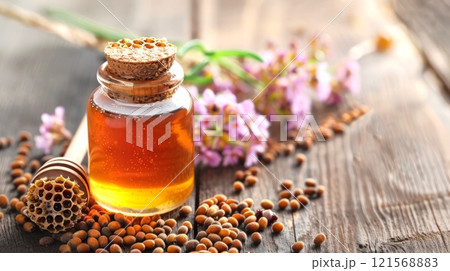 Honey jar with cork and wildflowers on wooden surface. Rustic honey presentation. Concept of organic farming, countryside delights, and floral notes Honey jar with cork and wildflowers on wooden surface. Rustic honey presentation. Concept of organic farming, countryside delights, and floral notes 121568883