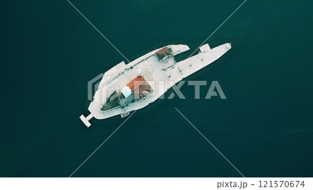 Aerial top down view of a small isle with a boat and building Aerial top down view of a small isle with a boat and building 121570674