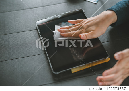 タブレット端末の画面を拭く女性 タブレット端末の画面を拭く女性 121573787