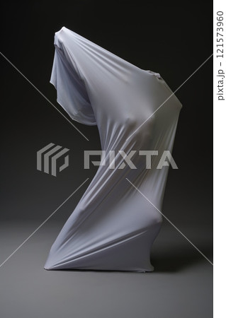 Draped figure forms a bold silhouette on a dark background Draped figure forms a bold silhouette on a dark background 121573960