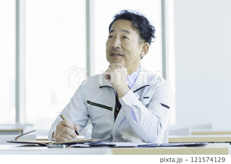 セミナーを受ける作業服のミドルエイジの男性　撮影協力：学校法人電波学園 東京電子專門学校 121574129