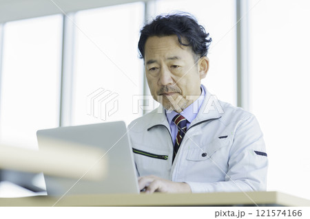 PC作業をする作業服のミドルエイジの男性　撮影協力：学校法人電波学園 東京電子專門学校 121574166