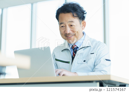 PC作業をする作業服のミドルエイジの男性 撮影協力:学校法人電波学園 東京電子專門学校 PC作業をする作業服のミドルエイジの男性 撮影協力:学校法人電波学園 東京電子專門学校 121574167