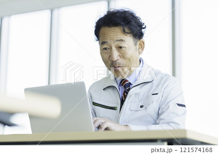 PC作業をする作業服のミドルエイジの男性　撮影協力：学校法人電波学園 東京電子專門学校 121574168