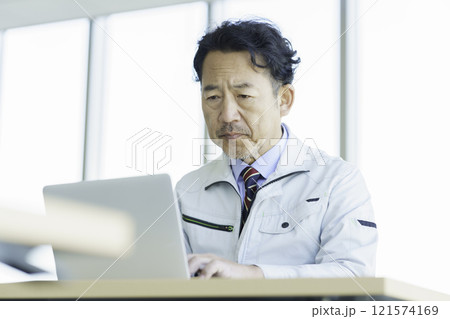 PC作業をする作業服のミドルエイジの男性　撮影協力：学校法人電波学園 東京電子專門学校 121574169