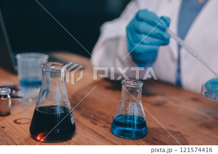 Blood test in the laboratory. Laboratory assistant working with the dispenser. Vacuum tubes with blood. 121574416