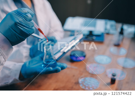 Blood test in the laboratory. Laboratory assistant working with the dispenser. Vacuum tubes with blood. 121574422