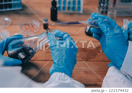 Blood test in the laboratory. Laboratory assistant working with the dispenser. Vacuum tubes with blood. 121574432