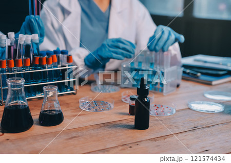 Blood test in the laboratory. Laboratory assistant working with the dispenser. Vacuum tubes with blood. 121574434