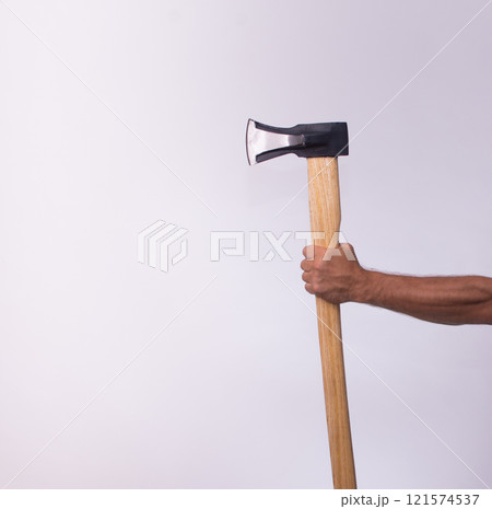 A man's hand holding an axe for chopping wood. A man's hand holding an axe for chopping wood. 121574537