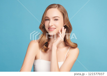 Beautiful young woman with clean fresh skin on blue background, Face care, Facial treatment, Cosmetology, beauty and spa, women portrait. Beautiful young woman with clean fresh skin on blue background, Face care, Facial treatment, Cosmetology, beauty and spa, women portrait. 121577037