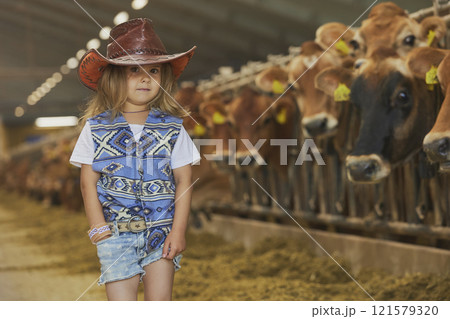Charming child in a cowboy costume on a cows farm in Denmark Charming child in a cowboy costume on a cows farm in Denmark 121579320