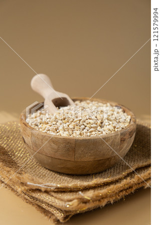 Pearl barley in neutral beige background. Whole spelt grain species. High protein fiber-rich vegan plant based food ingredient. Gluten free superfood healthy nutritional dietary alternative 121579994