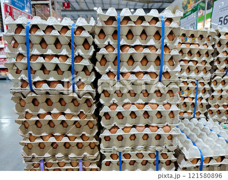 Fresh Eggs Stacked Neatly in Cardboard Cartons at Grocery Store 121580896