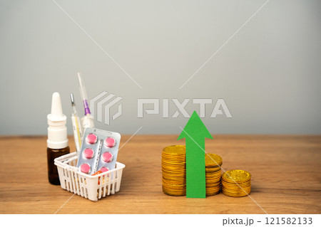 Up arrow, coins and basket with medical pills. Concept of growth the price of medicines and drugs. Healthcare and medicine 121582133