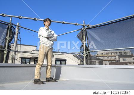 戸建て家屋の屋根修理工事の男性現場監督者 戸建て家屋の屋根修理工事の男性現場監督者 121582384