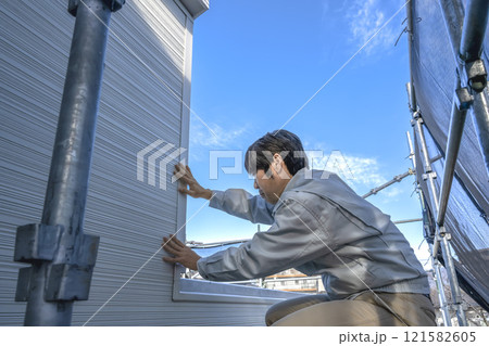 戸建て家屋の外壁重ね張りリフォーム工事の男性現場監督者 121582605