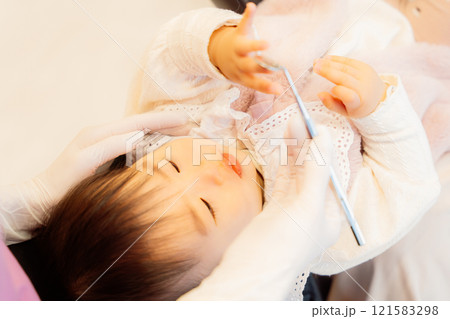 乳児検診を受けて不安顔な乳児 121583298