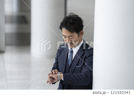 腕時計を見る50代後半のビジネスマン 腕時計を見る50代後半のビジネスマン 121583341