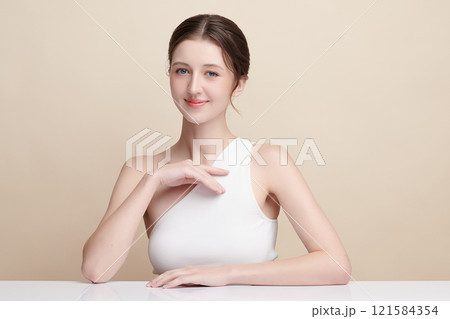 Beautiful young woman with clean fresh skin on beige background, Face care, Facial treatment, Cosmetology, beauty and spa, women portrait. 121584354
