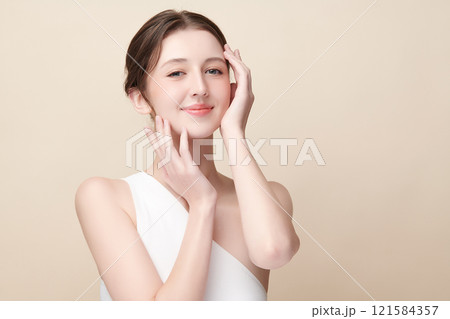 Beautiful young woman with clean fresh skin on beige background, Face care, Facial treatment, Cosmetology, beauty and spa, women portrait. 121584357