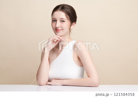 Beautiful young woman with clean fresh skin on beige background, Face care, Facial treatment, Cosmetology, beauty and spa, women portrait. 121584358