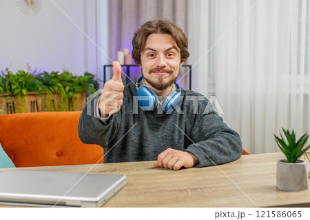 Happy Caucasian young man looking approvingly at camera show thumbs up like positive sign good news 121586065