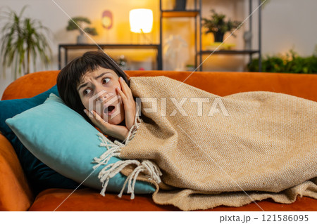 Woman suddenly wakes up from nightmare while sleeping on couch due to anxiety, disorder, bad dreams 121586095