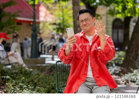 Surprised Asian man use smartphone loses, bad news, fortune loss, fail outdoors in city street Surprised Asian man use smartphone loses, bad news, fortune loss, fail outdoors in city street 121586168