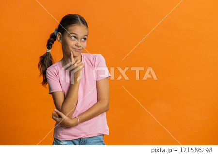 Thoughtful clever young preteen child girl kid pondering a solution doubting question brainstorming 121586298