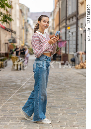 Tourist traveler young woman using smartphone search a way on map in navigator app on city street Tourist traveler young woman using smartphone search a way on map in navigator app on city street 121586309