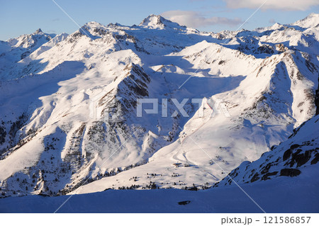 Breathtaking view of snow-covered mountain range, showcasing ski slopes and towering peaks, alpine ski resort Breathtaking view of snow-covered mountain range, showcasing ski slopes and towering peaks, alpine ski resort 121586857