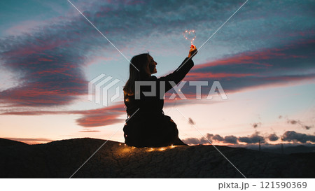 Girl At Sunset Holding A Heart Symbol 121590369