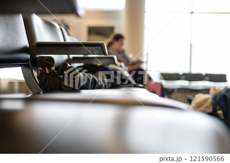 Selective focus on the feet of a child asleep on a row of chairs in an airplane terminal Selective focus on the feet of a child asleep on a row of chairs in an airplane terminal 121590566