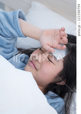 発熱で頭を冷やして風邪をひいて寝込む子ども 121590794