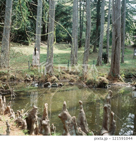 森の中の湖に立つワンピースの女性 121591044