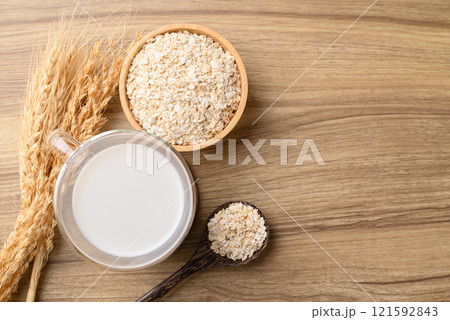 Oat milk in cup glass on wooden table, Alternative milk made from plant, non dairy Oat milk in cup glass on wooden table, Alternative milk made from plant, non dairy 121592843